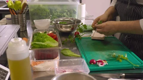 A chef cuts fresh vegetables in a spacious modern kitchen in a restaurant. Video stock 277133209