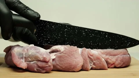 Chef cuts with a knife and prepares a piece of pork for delicious meat dishes. Stock Footage 153433730