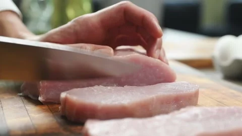 The chef cuts with a knife the raw pork loin. Stock Footage 200810810