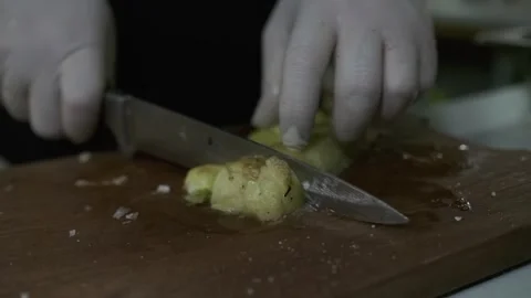 The chef cuts large pieces of zucchini with a knife on a cutting board. Stock Footage 248871907