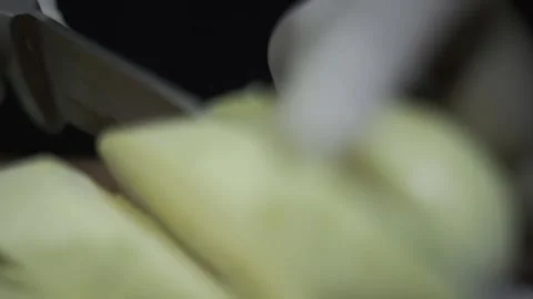 The chef cuts large pieces of zucchini with a knife on a cutting board. Stock Footage 249582337