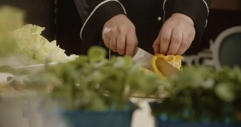 Chef cuts large yellow sweet bell pepper with sharp knife. 4K Slow Motion Stock Footage 113513231