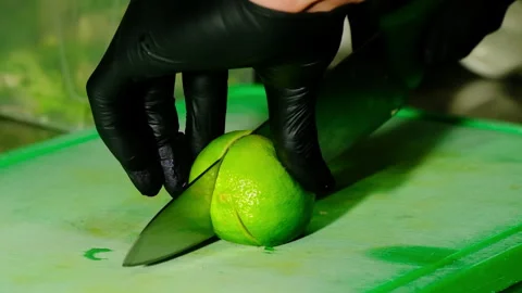 Chef cuts lime wedge for pad thai plating in busy kitchen Stock Footage 324848221
