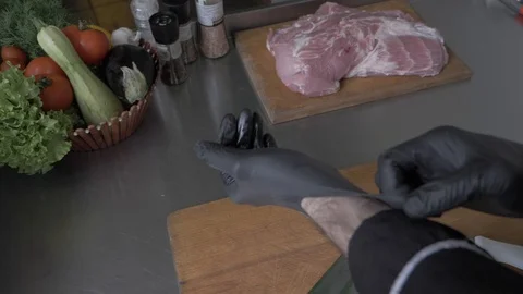 The chef cuts meat, herbs and tomatoes on the kitchen table with a sharp knife 스톡 동영상 108146069