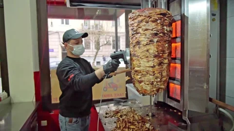 Chef cuts meat for shawarma with a machine Stock Footage 188462985