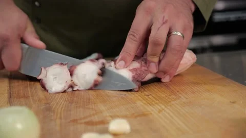 Chef cuts the octopus with a sharp knife.squid tentacles Stock Footage 163971212
