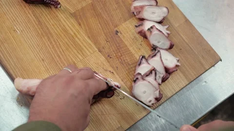 Chef cuts the octopus with a sharp knife.squid tentacles Stock Footage 163971253