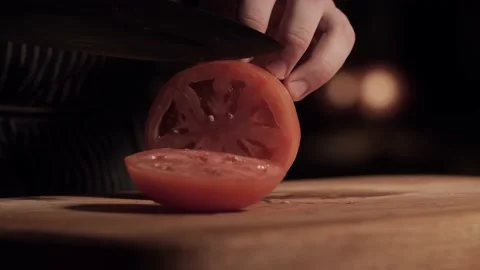 Chef cuts one ring from tomato and puts knife on cutting board. Close-up Stock Footage 135880459