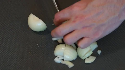 Chef cuts onion. Cooking process. Hands cutting onion. Chef slices the onion Stock Footage 100106649