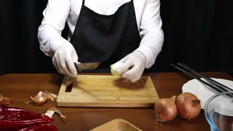 Chef cuts onion in half with black background Stock-Footage 190070050