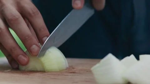 Chef cuts onion into pieces close up of hand and knife full HD video Stock Footage 130768997