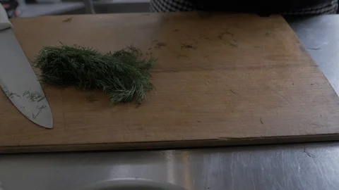 The chef cuts onions, herbs and tomatoes on the kitchen table with a sharp knife Stock Footage 108150409