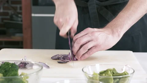 Chef Cuts Onions In Restaurant Kitchen On Cutting Board. Cooking Food. Stock Footage 142807430