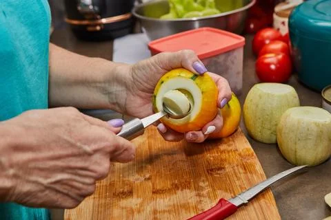 Chef cuts out the inside of zucchini for stuffing in home kitchen Stock Photos