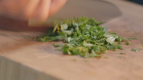 Chef cuts parsley for salad basil on a cooker chopped for food Stock Footage 129607731