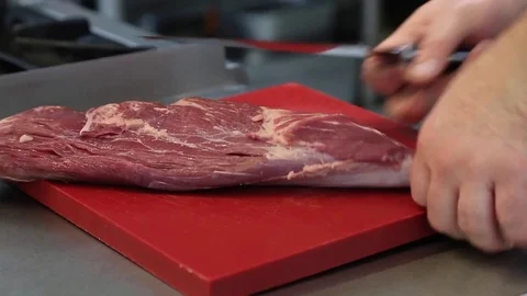 The chef cuts a piece of meat with a kitchen knife Stock Footage 83587430