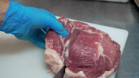 A chef cuts a piece of raw meat Stock Footage 149757060