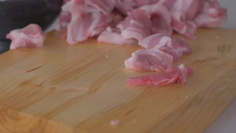 Chef cuts pieces of raw bacon by sharp knife on the wooden board Video stock 111270981