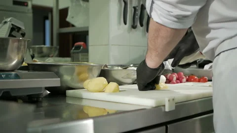The chef cuts the potatoes in black gloves. Cooking a dish Stock-Footage 106334437