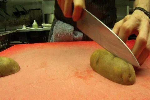 Chef Cuts Potatoes on Cutting Board Stock Footage 11158957