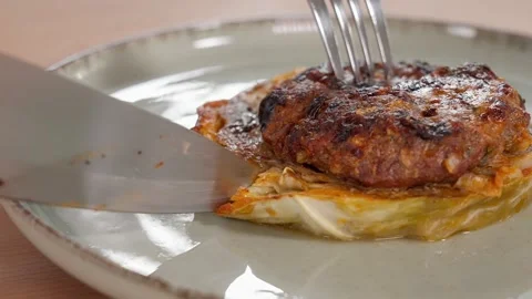 The chef cuts the prepared dish with cutlet and cabbage Stock Footage 265177414
