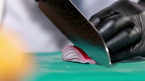 Chef cuts up purple onion using knife to slice. Close up Stock Footage 75394472