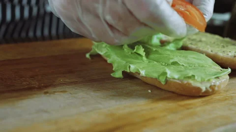 Chef Cuts Puts Tomatoes On the Sandwich Stock Footage 64688433