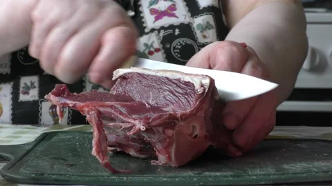 Chef cuts raw deer meat with a knife Stock Footage 197931993