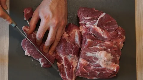 The chef cuts raw meat with the knife. Chef cutting pork meat. Cutting meat Stock Footage 99392772