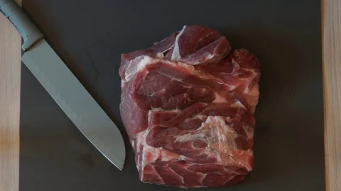 The chef cuts raw meat with the knife. Chef cutting pork meat. Cutting meat Stock Footage 99880360
