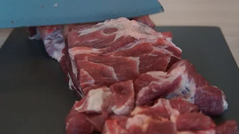 The chef cuts raw meat with the knife. Chef cutting pork meat. Cutting meat Stock Footage 99880823