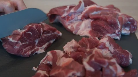 The chef cuts raw meat with the knife. Chef cutting pork meat. Cutting meat Stock Footage 99880989
