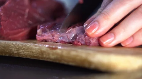 The chef cuts raw meat with the knife Stock Footage 109661212