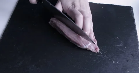 The chef cuts raw meat with the knife Stock Footage 125608033