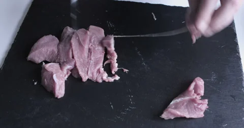 The chef cuts raw meat with the knife Stock Footage 125608328