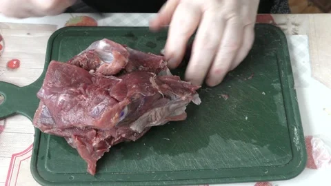 Chef cuts raw meat with a knife Stock Footage 173568097