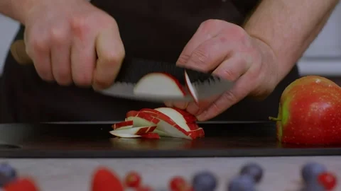A chef cuts a red apple into strips close-up. A juicy, ripe, healthy apple with Stock Footage 269161419