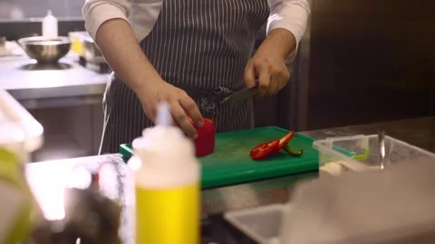 Chef cuts red bell pepper in restaurant kitchen. Stock Footage 277131545