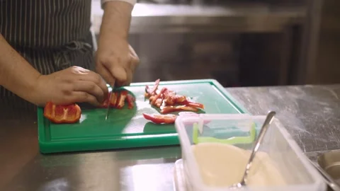Chef cuts red bell pepper in restaurant kitchen. Video stock 277131551