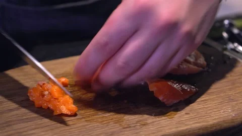 The chef cuts red fish, a delicacy, with a knife. Red fish salad. Close ap. Video stock 171682183