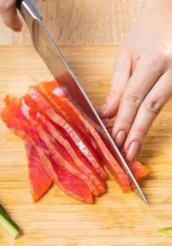 The chef cuts red fish with a knife Foto stock