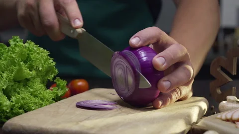 Chef cuts the red onion by the sharp knife on the wooden board Stock Footage 143777557