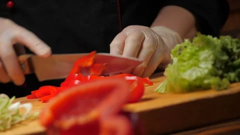 Chef cuts red pepper with a knife. Video stock 242096504
