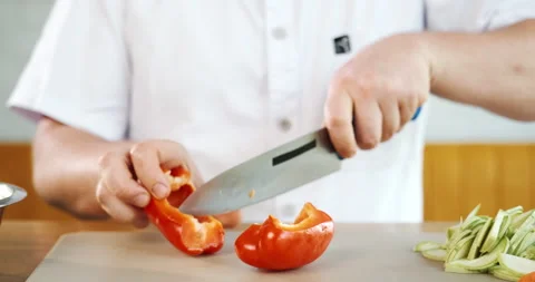 Chef cuts red pepper, preparing vegetables for cooking, camera sliding. Stock Footage 133368072