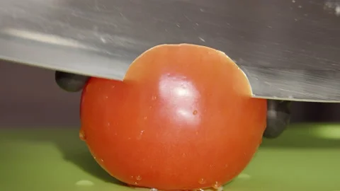 The chef cuts a ripe tomato with a large knife, close-up Stock Footage 142732160