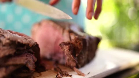 Chef cuts the roast beef into thin slices with a large knife Video stock 270041911