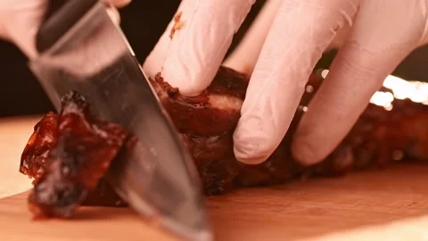 Chef cuts roasted beef meat with a knife to slices Stock Footage 149078605