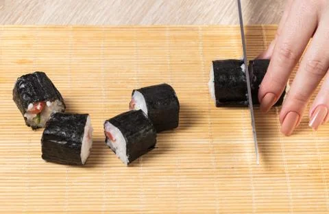 Chef cuts rolls, hands close-up Stock Photos