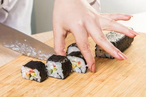 Chef cuts rolls, hands close-up Stock Photos