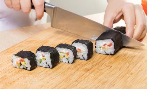 Chef cuts rolls, hands close-up Foto stock
